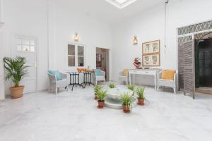 ein Wohnzimmer mit Topfpflanzen auf dem Boden in der Unterkunft Casa de Tintes in Sevilla