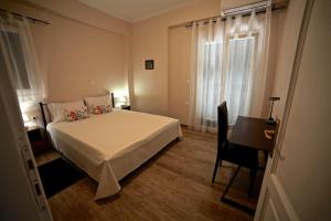 a bedroom with a bed and a desk and a window at Kanoni Apartment in Corfu Town