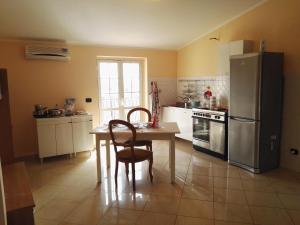 Marina di Sellia的住宿－Sellia apartment，厨房配有桌子和不锈钢冰箱。