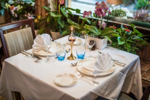 a white table with plates and glasses and flowers at Hotel Brimer in Grundhof