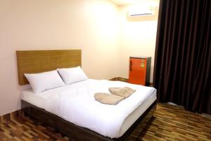 een slaapkamer met een groot bed met witte lakens bij Banpong Center Place in Ban Khung Phayom
