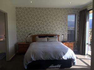 a bedroom with a large bed and a window at The Rock in Te Anau