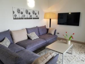 a living room with a blue couch and a table at Luxury Apartments Beauty Gardens in Sirmione