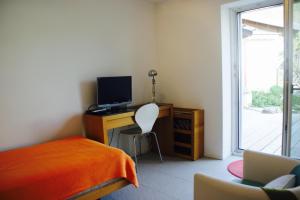 a bedroom with a bed and a desk with a computer at N1 Standalone House Baden in Hertenstein