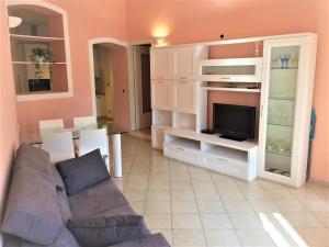 a living room with a couch and a tv at Casetta sulla Baia del Silenzio in Sestri Levante