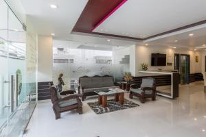 sala de estar con sillas, mesa y TV en Treebo Trend Raj Premier - Indiranagar en Bangalore