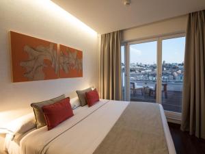 um quarto de hotel com uma cama grande e uma varanda em Hotel Carris Porto Ribeira em Porto