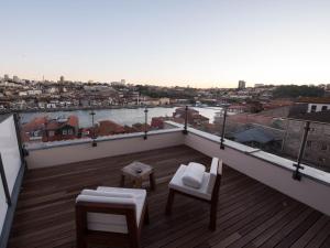 a balcony with chairs and a view of a city at Hotel Carris Porto Ribeira in Porto