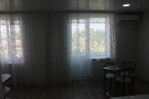 a room with two windows and a table and chairs at Studio on main street in Bălţi