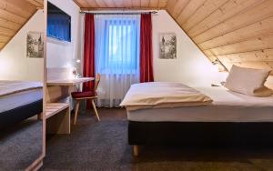 a hotel room with two beds and a window at Gasthof Adler in Schillingsfürst