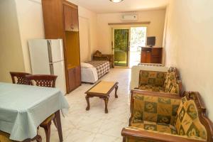 a living room with a table and a refrigerator at Chrysanthos Boutique Apartments in Limassol