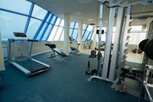 a gym with cardio equipment in a building with windows at Hotel El Paraiso in Adler