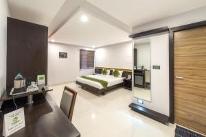 a hotel room with a bed and a desk at Treebo Trend Raj Premier - Indiranagar in Bangalore