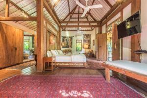 a bedroom with a bed and a flat screen tv at Wayang Retreat in Canggu