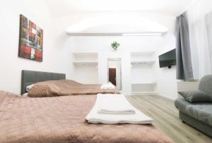 a hotel room with two beds and a couch at Apartma City & Free Parking in Ljubljana