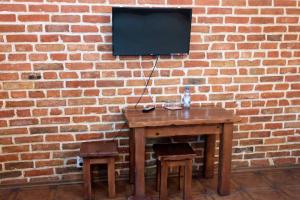 a wooden table with two chairs and a television on a brick wall at Fortetsya in Uman