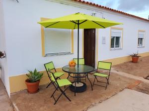 un tavolo da patio con sedie e ombrellone verde di Quinta Teresinha a Silves