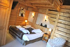 ラ・クリュサにあるHôtel Chalet Alpageの木造キャビン内のベッド1台が備わるベッドルーム1室を利用します。