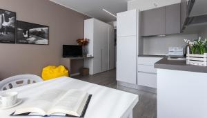 uma cozinha com uma mesa branca com um livro aberto em Italianway-Cadorna 10A Flat em Milão