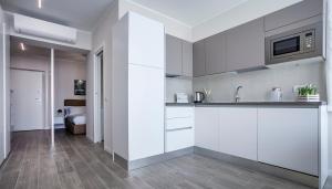 a white kitchen with a sink and a microwave at Italianway-Cadorna 10A Flat in Milan