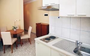 a kitchen with a sink and a table with a stove at Apartments Barisic Hrvatskih Žrtava 404 Seget Vranjica in Trogir