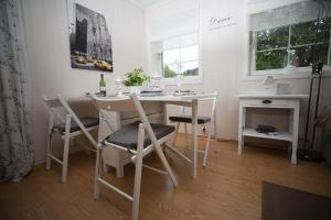 a white dining room with a table and chairs at Apartment at Ranheim in Trondheim
