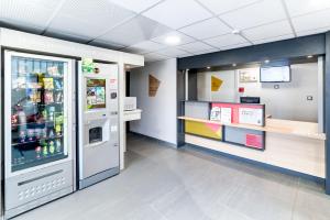 un magasin avec un réfrigérateur et un comptoir dans l'établissement B&B HOTEL Chalon-Sur-Saone Sud, à Saint-Rémy