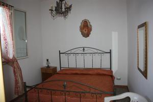 Schlafzimmer mit einem Bett und einem Kronleuchter in der Unterkunft Carrube House in Andrano