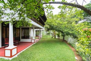 ein Haus mit einer roten Veranda und einem grünen Hof in der Unterkunft The Windsor Castle in Kottayam