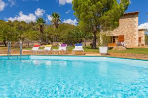 a swimming pool with chairs and a house at Banyols in Alaró