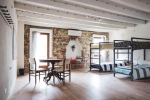 een kamer met een tafel en stoelen en een stapelbed bij The Hostello in Verona