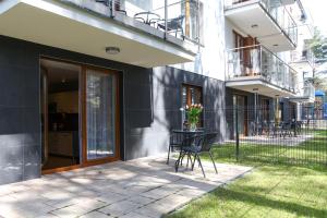 a patio with chairs and a table in front of a building at Apartamenty w Marina Jastrzębia Góra in Jastrzębia Góra