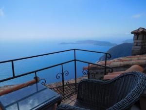 uma varanda com uma mesa e cadeiras e o oceano em La Suite du Village d'Eze em Èze