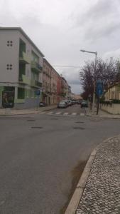 an empty street with cars parked on the side of the road at Casa do Jardim Escola in Tomar