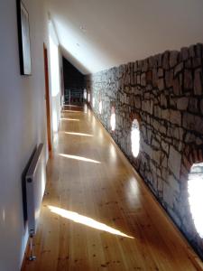 um corredor com uma parede de pedra e um piso de madeira dura em Augherea House em Longford