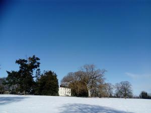 un campo cubierto de nieve con una casa en el fondo en Augherea House, en Longford