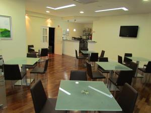 a cafeteria with green tables and chairs and a kitchen at Sao Tomas in Fátima