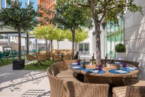 an outdoor patio with tables and chairs and trees at Barceló Imagine in Madrid