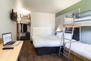 a room with two bunk beds and a desk with a laptop at B&B HOTEL Corbeil-Essonnes in Corbeil-Essonnes