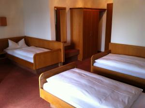 Habitación con 2 camas y una silla. en Hotel Bacchusstube garni, en Goldbach