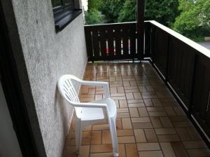 einen weißen Stuhl auf dem Balkon in der Unterkunft Hotel Bacchusstube garni in Goldbach