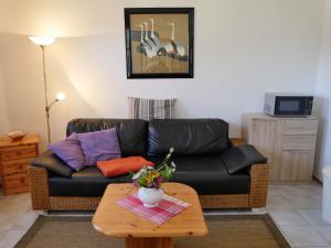 sala de estar con sofá de cuero negro y mesa en Ferienhaus Caspar David Friedrich, en Lohme
