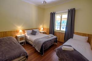 a bedroom with two beds and a window at Lewana Cottages in Balingup