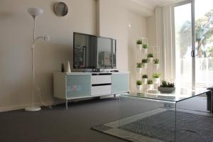 a living room with a television on a white dresser at Enjoyable Holiday Home For Group Six in Waitara