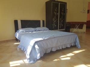 1 dormitorio con 1 cama con mantas y almohadas blancas en Noor Guesthouse, en Kampong Alor Ganu
