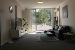 a living room with a couch and a large window at Enjoyable Holiday Home For Group Six in Waitara