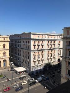 un grand bâtiment blanc avec des voitures garées dans un parking dans l'établissement Maison Arena Bovio, à Naples