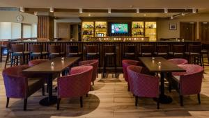 un restaurante con mesas y sillas y un bar en Rochestown Lodge Hotel, en Dun Laoghaire