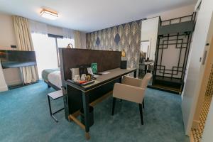 a room with a desk and a bedroom with a bed at Best Western Hôtel Journel Saint-Laurent-du-Var Aéroport in Saint-Laurent-du-Var