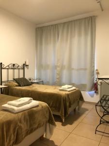 a bedroom with two beds and a window at Faro del Parque in Córdoba
